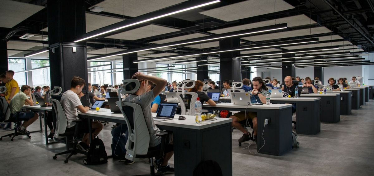 Open office with rows of workers on laptops